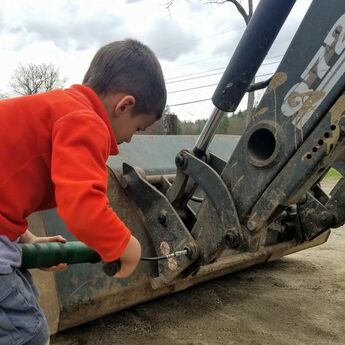 child repairing tractor